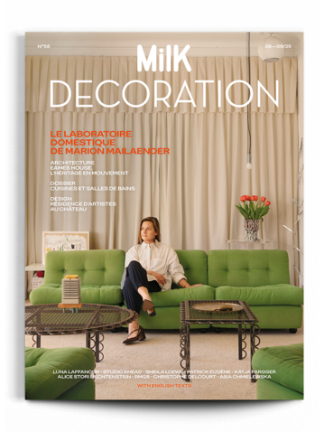 Cover of Milk Decoration magazine featuring a woman sitting on a green sofa in a stylish interior, with curtains and decorative plants in the background.